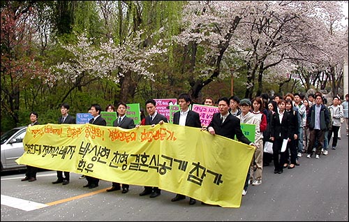 한총련 정치 수배자 박상현씨는 형의 결혼식에 참석하기 위해 '공개 결혼식 참가 행진'을 벌였다. 사진은 12일 경희대 크라운관에서 기자회견을 마치고 내려오는 박상현씨와 경희대 학생들. 